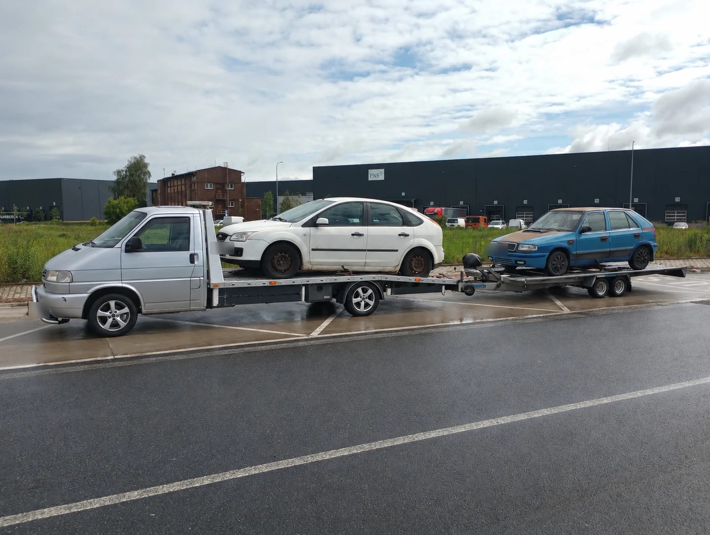 Odťahová VW T4 s bielym Fordom Focus na plošine a modrou Škodou Felicia na prívese